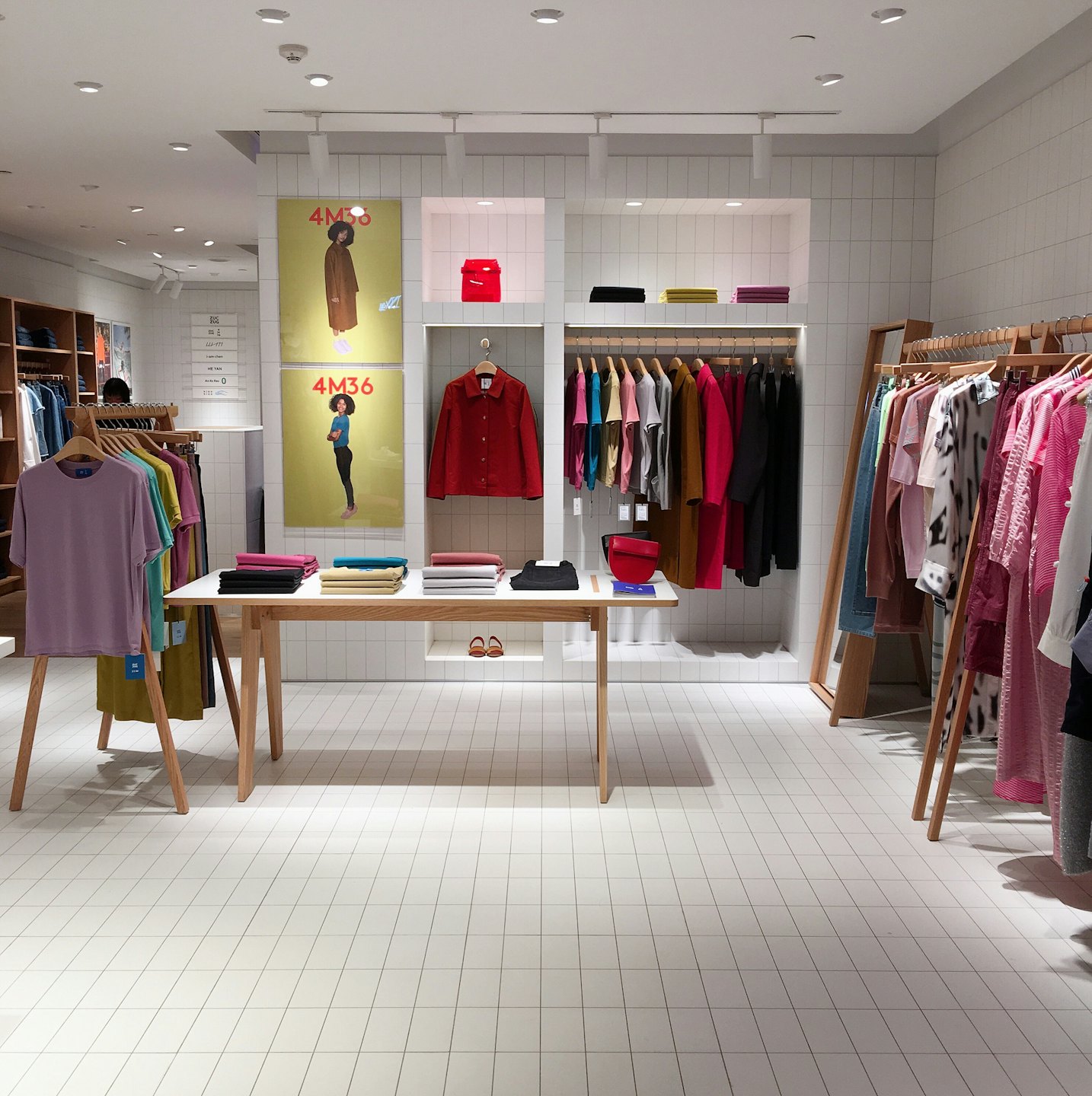 Moderne kledingwinkel interieur met kleding op rekken en een displaytafel.